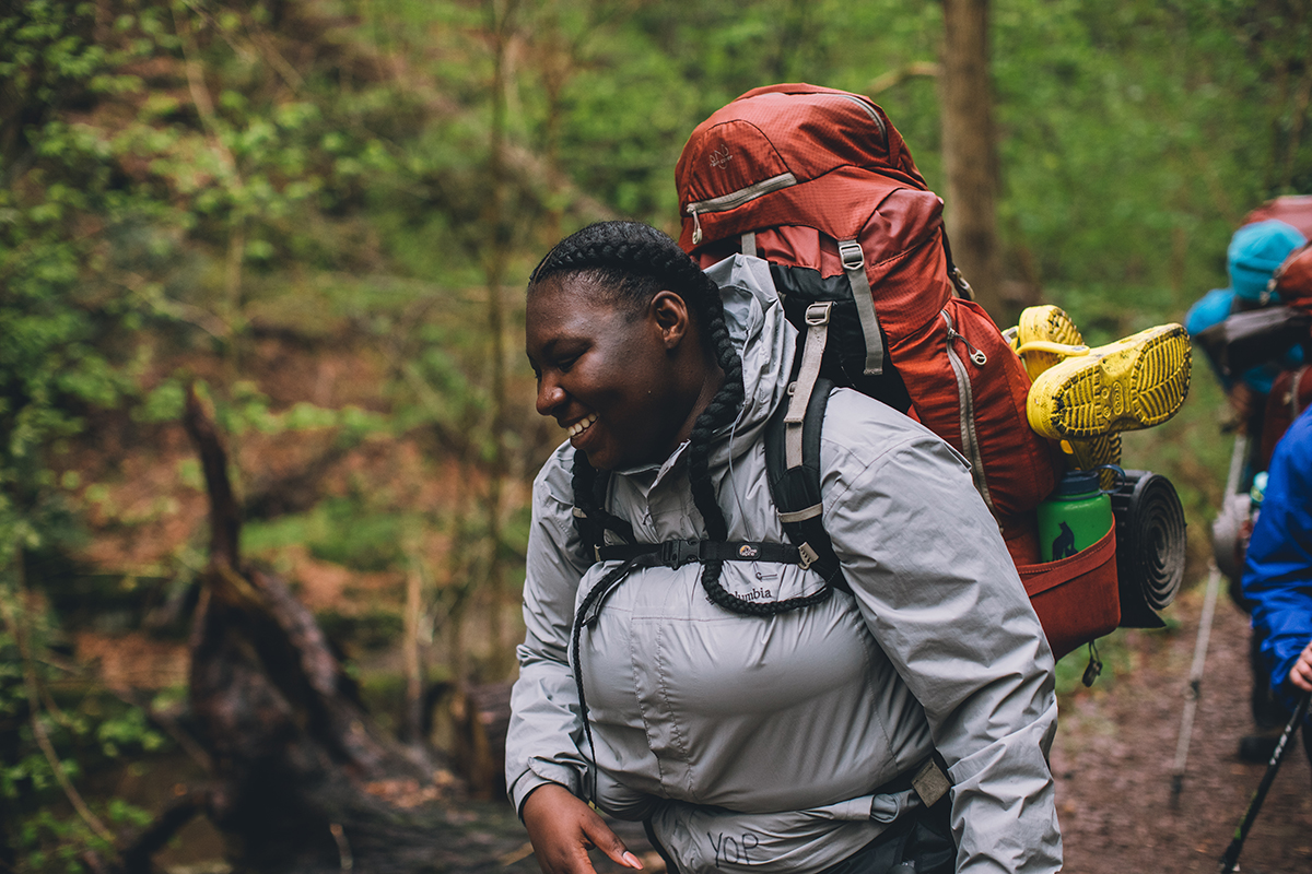 A womman with a backpack filled with gear